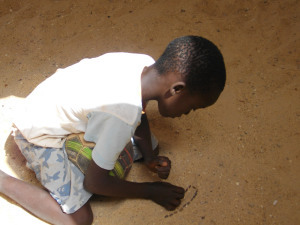 boy making design in sand