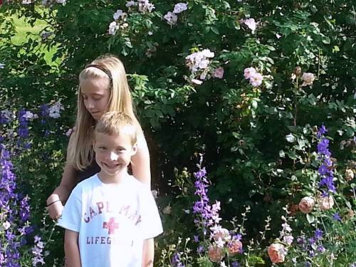 Emma and Owen beside the old pink rose with larkspur1