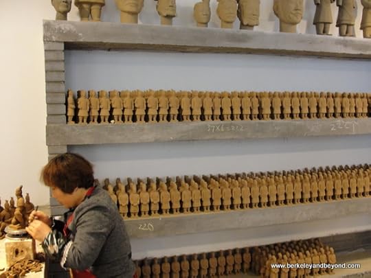 woman in factory reproducing Terracotta Warriors souvenirs in Xi'an, China