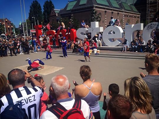 Street performers in front of the famous I Amsterdam sign.