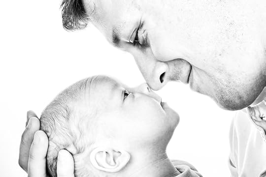 High key portrait in black and white, of a father lovingly embracing his newborn son