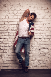 Sexy male model posing with white T-shirt and jeans on. Looking stylish