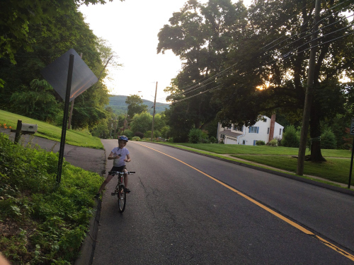 Child on bike, resting at top of hill