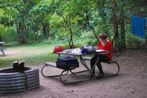 woman sitting at picnic table writing