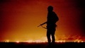 1991, a U.S. soldier standing night guard as oil wells burn in the distance in Kuwait
