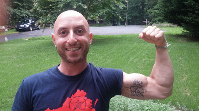 Benjamin Rubenstein with new inner bicep tattoo of fig tree and droplets of green water