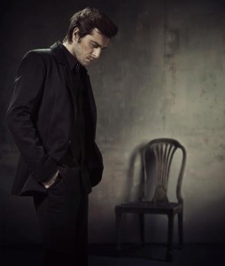 Handsome and calm man in a business suit on a dark background