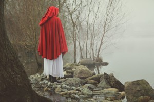 Little red riding hood on a shore of a misty lake