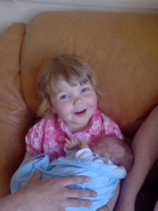 Little girl holding baby boy in her arms