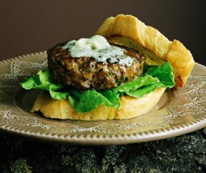 A lamb burger on baguette and lettuce leaves