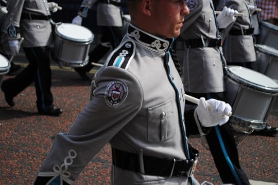 Gray-suited marching band walks by