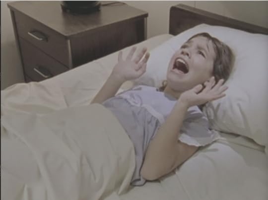 Celia in her hospital bed, screaming, with her hands up as though she's trying to push something away
