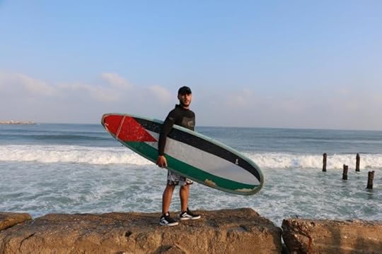 Photo: Taha Baker stands with his surfboard on a beach in Gaza. Laura Dean/Global Post 