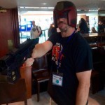 Photo of Gav with Andy Poulastides' Judge Dredd Cosplay helmet and gun