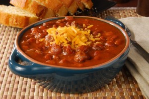 A bowl of hot chili with melted cheese