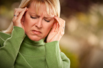 grimacing woman suffering a headache