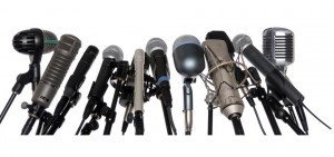 Various microphones aligned at press conference isolated over a white background