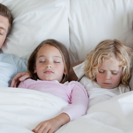 Family Sleeping In Bed