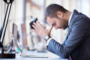 frustrated young business man working on laptop computer at offi