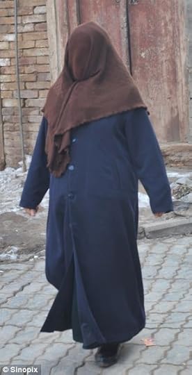 A Muslim woman wears a shroud to hide her face on the streets of Kashgar