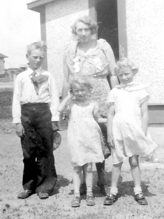 Grandma and her three children in front of the tiny house in Benson