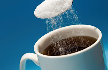 artificial-sweeteners being put in a coffee cup-350
