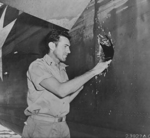 Lt. Louis Zamperini, bombardier of B-24D Liberator 'Superman' inspects hole from a 20mm shell over Nauru, Apr 20 1943; photo taken at Funafuti, Gilbert Islands. (US National Archives)