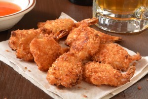 Coconut shrimp on a bar napking with a mug of beer