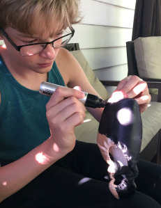 Photo by Nadine Baker / Cameron Baker colors his pointe shoes black.