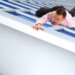 business man climbing a building almost reaching the top