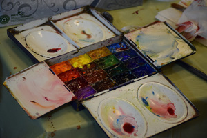 Charles Reid's palette filled with fresh paint. He dipped his brush in and put it on the paper. 