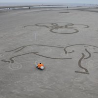 Those posts embedded in the sand help the robot orient its position as well as the picture placement.