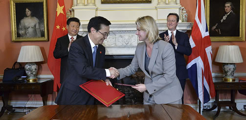 UK Development Minister Justin Greening and China's Commerce Minister Gao Hucheng seal the deal while their bosses look on