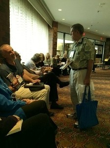 Bruce Coffin signing a book for John Clark. Dorothy Cannell and Kate Flora are at the far end of the signing line.
