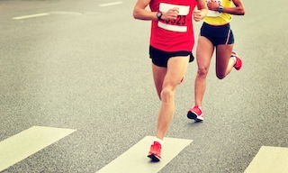 marathon runner legs running on city street