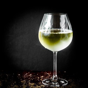 Glass of chilled white wine on wooden background