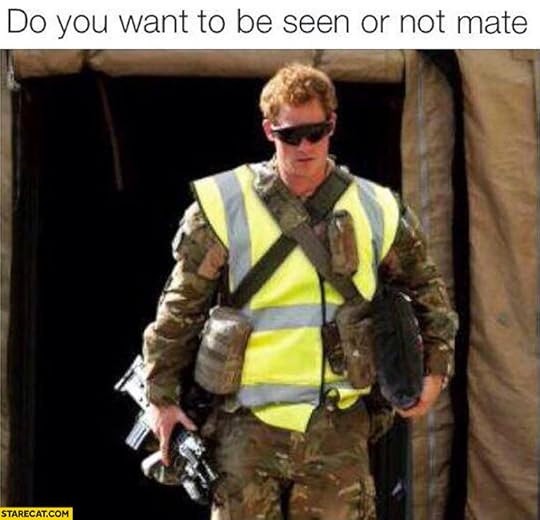 A photo of Prince Harry in camouflage fatigues and a high-visibility safety vest with the words 