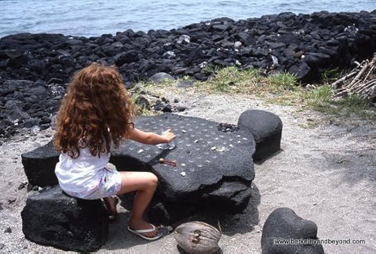 child playing konane checkers in Pu’uhonua O Honaunau National Historical Park/City of Refuge in Honaunau on Big Island, Hawaii