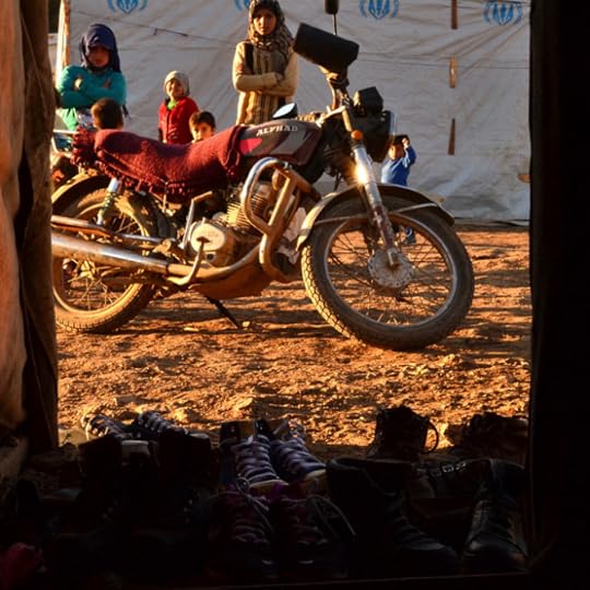 Women behind a motorcycle and in front of tents