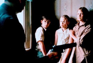 Kalle Blomkvist (glasses), a Swedish Nancy Drew, and his buddies Eva-Lotta and Anders threatened by a bad guy with a gun.