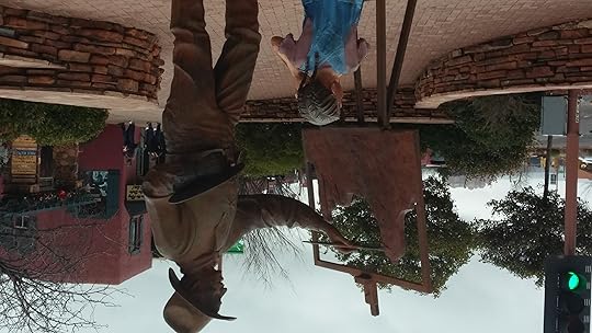 A statue of a cowboy painting with a little girl and a camera