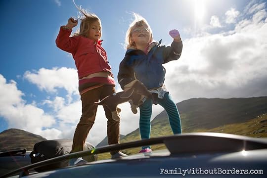 two little girls on top of car