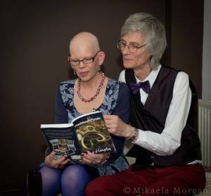 Leslie lighting Sue at Purple Mikaela event