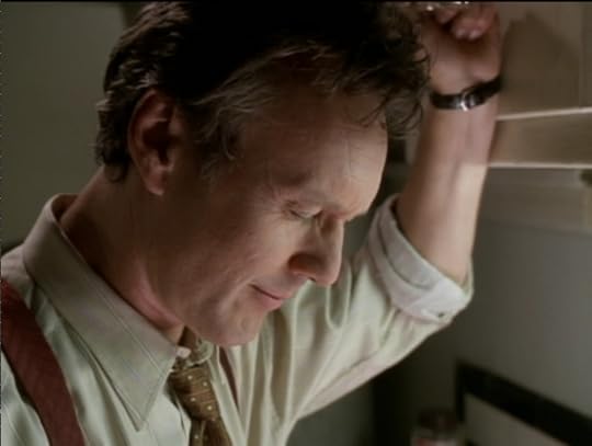 Giles leaning against a cupboard, his eyes closed, smiling.