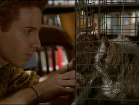 Oz leaning real close to the cage with the dead cat in it. That cat, by the way, is super dirty and gross and has blood coming out of its ears.