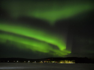 Northern lights (aurora borealis) display over a frozen lake in Lapland.