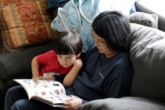 The Pip studying his Lego superhero book with Kate.