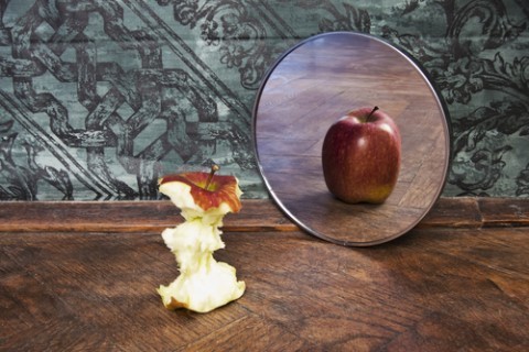surrealistic picture of an apple reflecting in the mirror