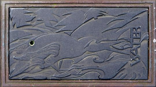 Stylized cormorant (?) on water meter covers 