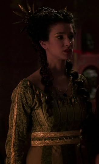 Niobe's dress is olive green with a lot of gold embroidery and embellishments